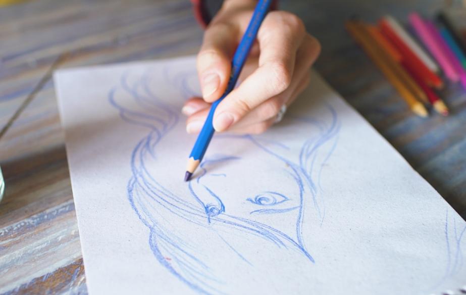 一位艺术家用蓝色铅笔在一张白色的纸上画了一个女人的素描